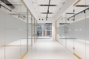 Moderne, lichte kantoorruimte aan de Generaal Vetterstraat met glazen wanden en zicht op een gebouw met grote ramen.